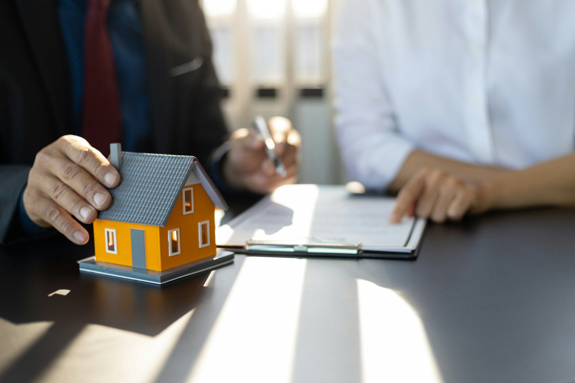 Insurance agent consulting real estate insurance detail to customer.